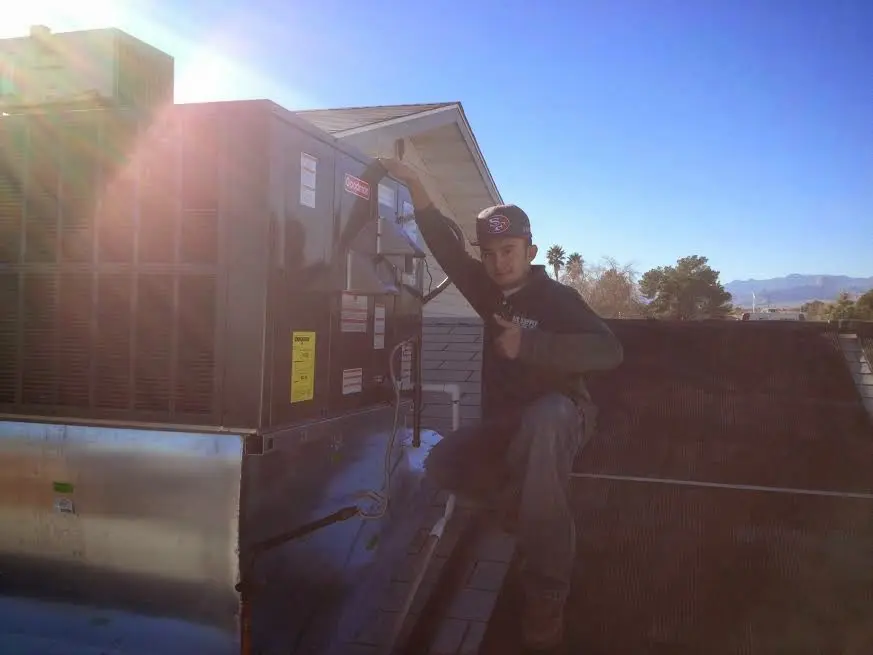 HVAC technician performing AC Tune-Up on a rooftop unit in New Albany
